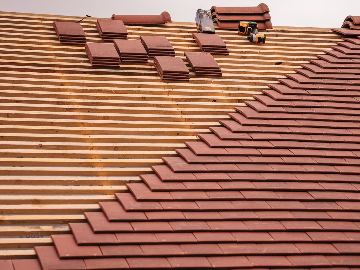 Instalação de telhas terracota em obra